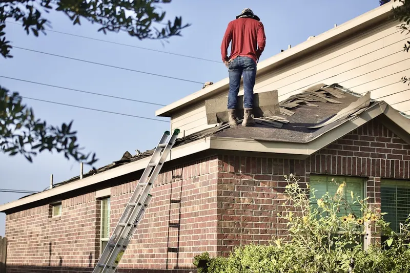 Professional roofer working on a residential roof in Elkview